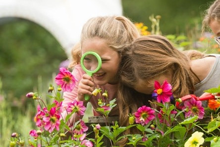 Girls playing with magnifying glass
