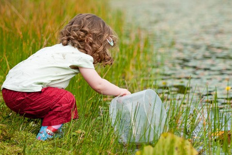 Girl pond dipping with a bucket